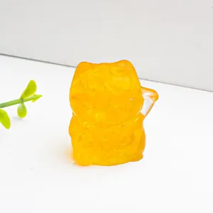 Transparente bernsteinfarbene Winkekatze aus Kunstharz mit Citrin-Kristallen auf weiß