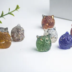 Primer plano detallado de búhos de resina con pan de oro e intrincada textura de plumas