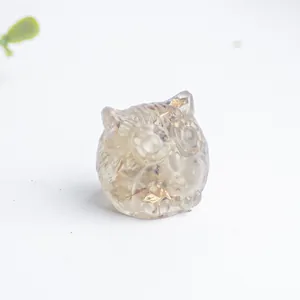 Detalle de figura de búho en resina transparente con copos dorados para decoración