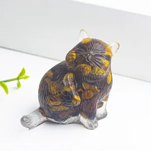 Dettaglio di una statuina di gatto in resina occhio di tigre con texture naturali