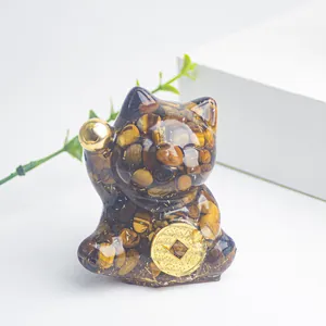 Dettaglio del gatto della fortuna in occhio di tigre con moneta d'oro e texture resina