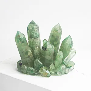 Vue détaillée du cristal vert translucide en forme de cluster sur support blanc