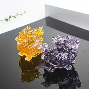 Detailed view of yellow and purple crystal dragon turtle figurines with resin glitter