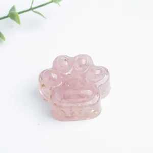 Detailopname van een roze hars kattenpoot ornament met decoratieve goudfolie snippers