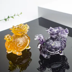 Detailed close-up of dragon turtle crystal resin statues in amber and purple colors