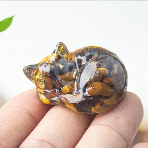 Macro view of a sleeping cat figurine made of tiger eye crystal resin and gold foil