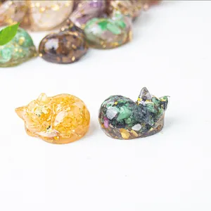 Detailed macro view of sleeping cat figurines filled with colorful crystals and gold foil