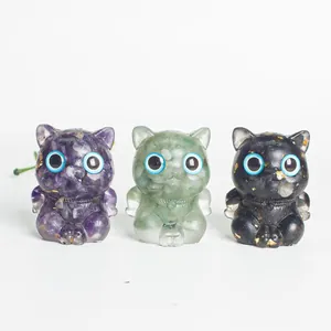 Gros plan de trois figurines de chats en résine de cristal en violet, vert et noir