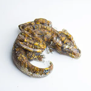 Detail of sleeping dragon resin figurine with natural crystal gravel and gold foil