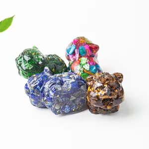 Detail of four handmade resin pig figurines with colorful natural crystal stones and gold foil