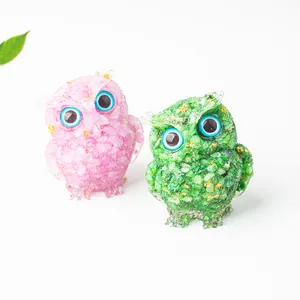 Macro detail of crystal resin owls with gold foil flakes and blue spherical eyes