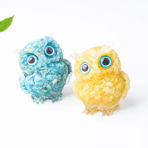 Detail showing crystal resin owl figurines with gold foil flakes and vivid blue eyes