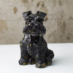 Detailed macro of a black resin Schnauzer statue with elegant gold leaf accents on the ears
