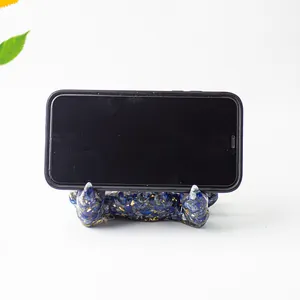 Close-up of blue crystal resin crab holder supporting a smartphone on white background