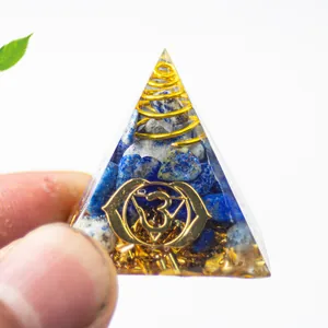 7 Chakra Naturkristall Orgonit Pyramide mit goldenem Om-Symbol in der Hand