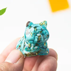 Detail of miniature blue resin cat figurine filled with natural stones and gold foil