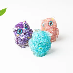Detailed view of crystal owl figurines with gold foil inclusions and large blue eyes