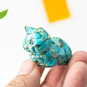 Macro shot of sleeping cat resin craft filled with turquoise stones and gold foil details