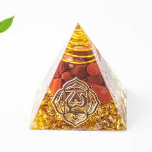 Makro-Detail der Orgonit-Pyramide mit rotem Jaspis und goldenem Wurzelchakra-Symbol