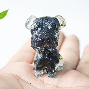 Miniatur-Schnauzer-Hundefigur aus Harz mit Goldflocken zwischen den Fingern