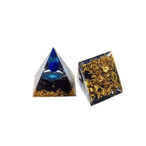 Orgonit-Pyramiden-Set mit blauer Kristallkugel und Goldflocken auf weißem Hintergrund