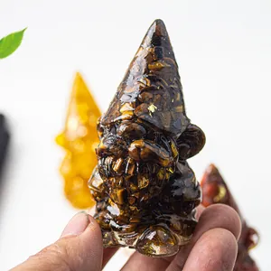 Handheld view of a clear resin gnome figurine filled with natural tiger eye crystals