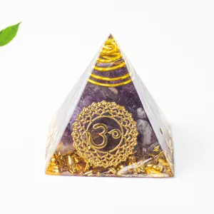 Makroaufnahme einer Orgon-Pyramide mit Amethyst-Steinen und goldenem Om-Symbol