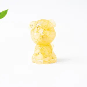 Close-up of a translucent yellow resin kitten figurine with amber texture and cute details