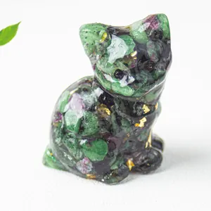 Close-up of cat figurine made of ruby zoisite crystal with gold foil detailing