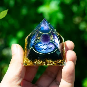 Detail of Aquarius orgone pyramid with purple crystal ball and golden foil base