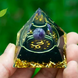 Detailed view of Capricorn crystal pyramid with amethyst sphere and gold foil interior