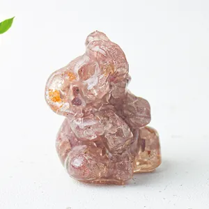 Close-up of pink crystal elephant figurine with red inclusions and detailed carving