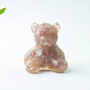 Macro di una statuetta di orso con pietre di cristallo rosa naturali in resina