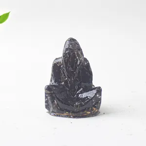 Primer plano de una figura de mago en resina de cristal oscuro sobre superficie pétrea