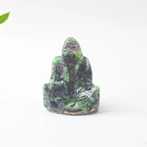 Vista detallada de pequeña estatua de Buda hecha con piedras de resina de cristal verde y lila