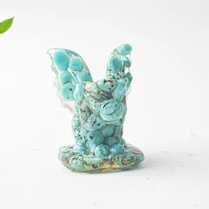 Détail des éclats de cristal turquoise incrustés dans une statue de gargouille en résine