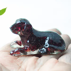 Miniature red crystal puppy resin figurine displayed in palm for size reference