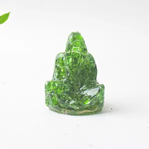 Detalle de una estatua de Ganesha de resina verde con piedras de cristal natural brillante