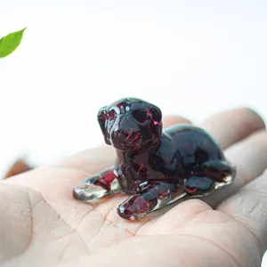 Close-up of a small resin crystal dog figurine held in hand for desktop decoration
