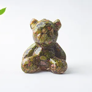 Dettaglio macro di un orso in resina riempito con cristalli naturali verdi e rossi