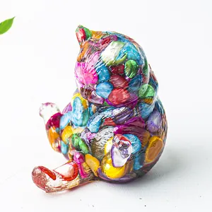 Dettaglio di una statuina a forma di gatto in resina con cristalli naturali colorati