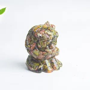 Macro detail of hand-carved unakite crystal cat figurine with natural green and pink texture