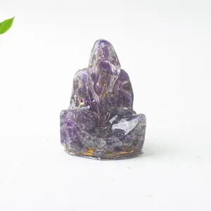Vista macro de estatua Ganesha de resina con fragmentos de cristal púrpura natural