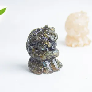 Macro shot of miniature guardian lion statue with labradorite crystal and iridescent finish