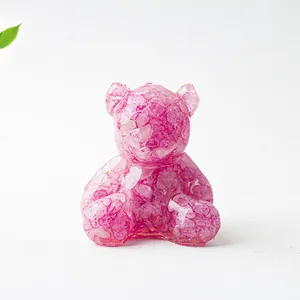 Dettaglio di un orsetto in resina e cristalli rosa con finitura lucida a specchio
