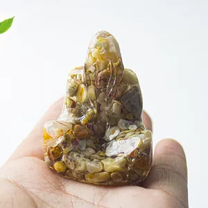 Estatua de Buda en resina y cristal natural para meditación sostenida en mano en entorno zen