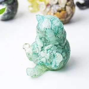 Vista macro di una statuina a forma di gatto in resina e cristallo naturale verde chiaro