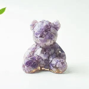 Dettaglio di orsetto in resina con frammenti di ametista viola e scaglie d'oro