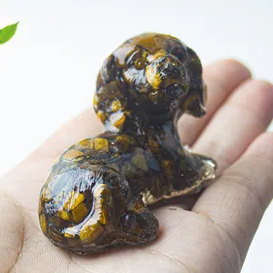 Miniature resin dog ornament filled with natural tiger eye crystal stones held in hand