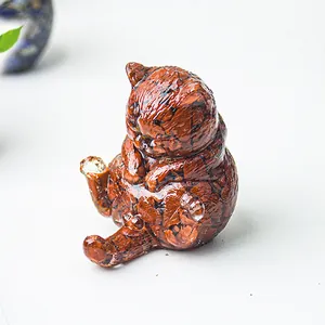 Vista macro di statuetta a gatto in resina con riempimento di pietre naturali rosse